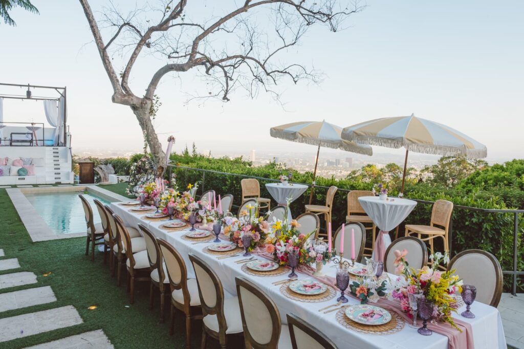 poolside tablescape with colourful flowers, plates and glasses