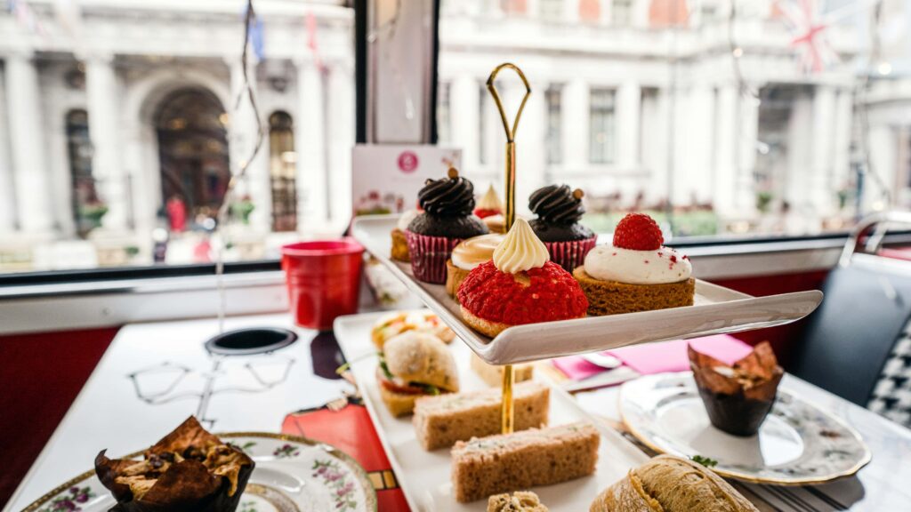 An English tea service onboard a bus driving through a picturesque London street.