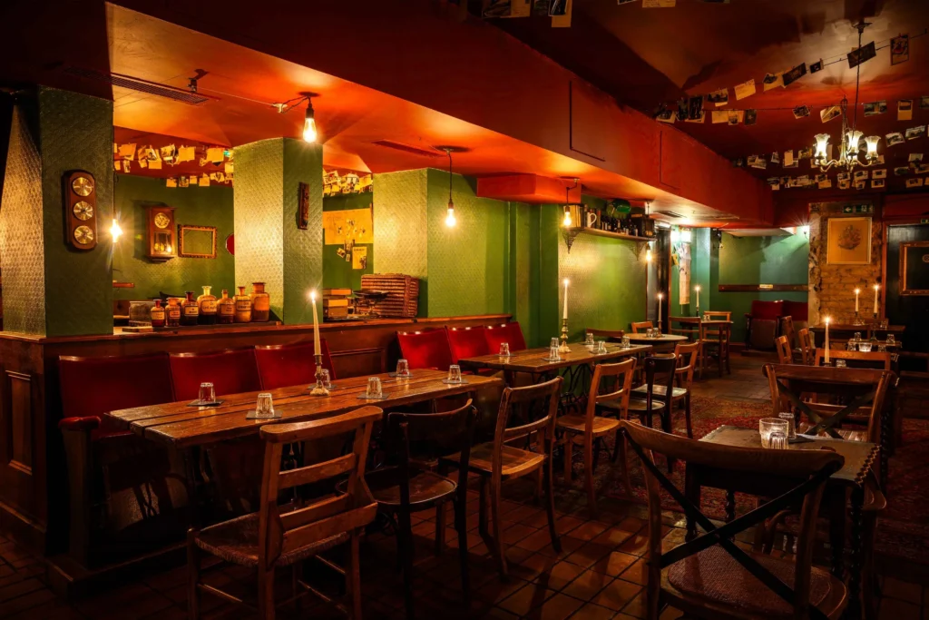 Evans and Peel Detective Agency London with green vintage walls, candlelit wooden tables and 1920s detective office speakeasy decor