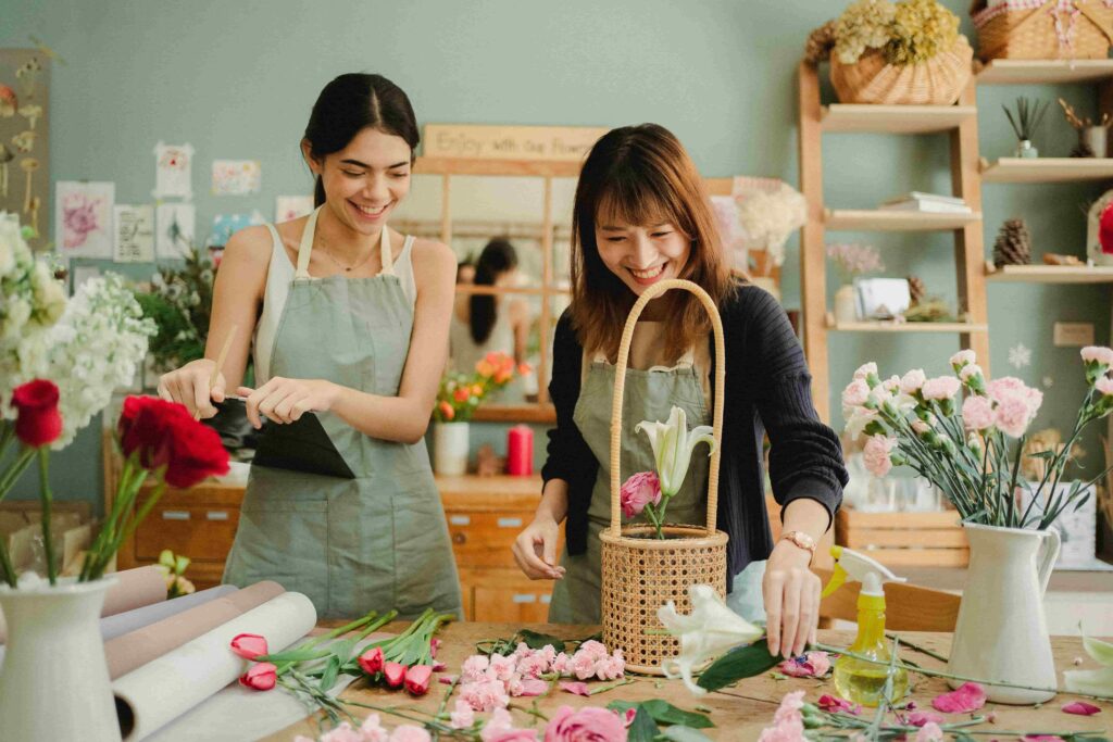 Two women arranging flowers in a flower decoration workshop.