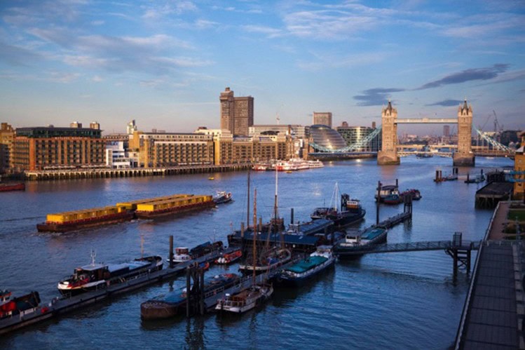 Historic boats at Hermitage Community Moorings with Tower Bridge in the background.