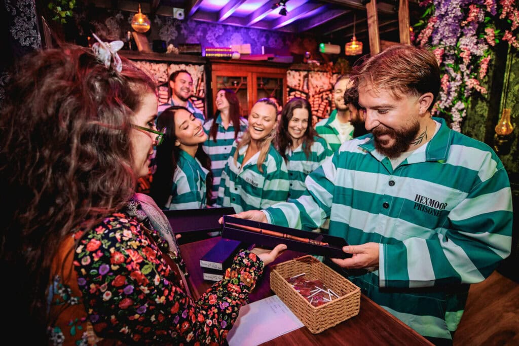 Guests in striped prison jumpsuits inside the Hexmoor wizarding prison experience in Shoreditch