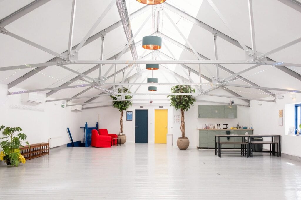 Bright London warehouse studio with skylights, exposed roof trusses and open floor space.