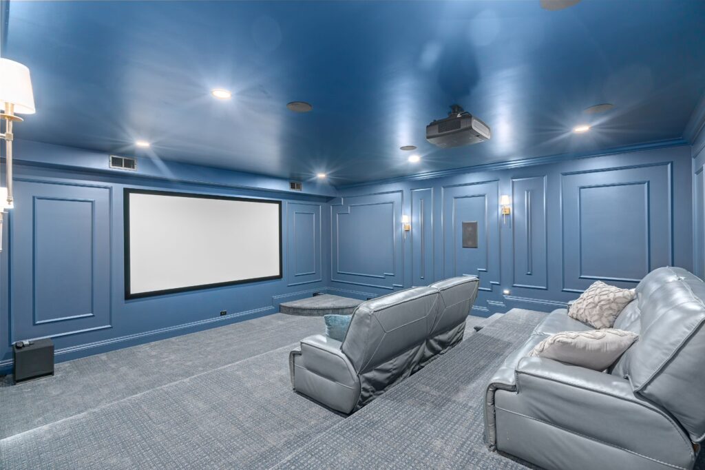 Blue screening room with comfy sofas and a large screen