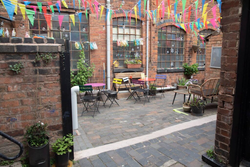 A brick-building patio with bunting and colorful chairs in Birmingham
