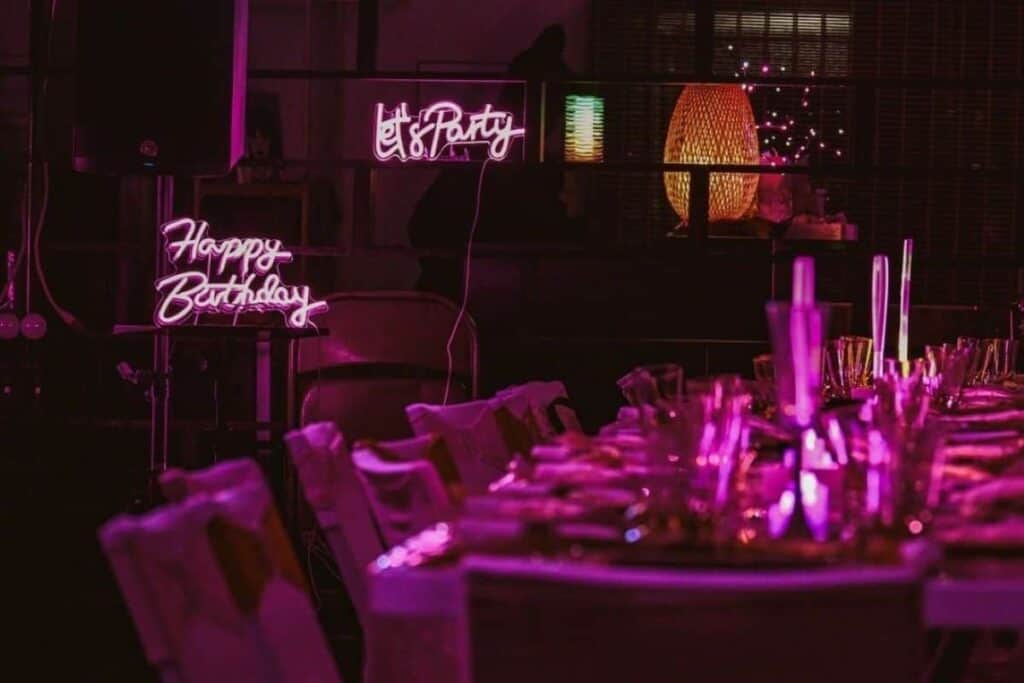 dinner party table lit by neon signs