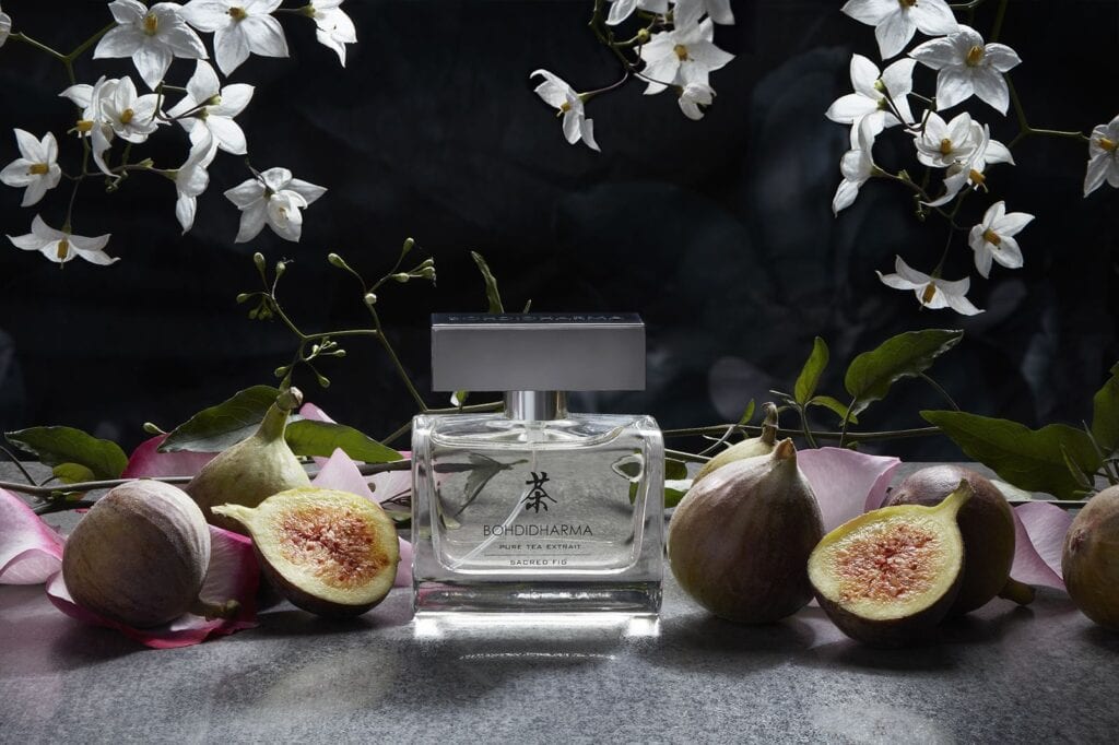 Bohdidharma Sacred Fig perfume bottle photographed among fresh figs and jasmine, styled still life by Elayne Barre
