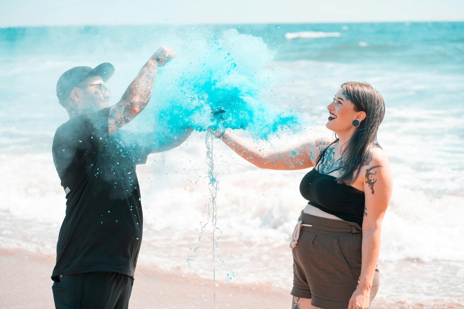 couple doing a gender reveal on a beach