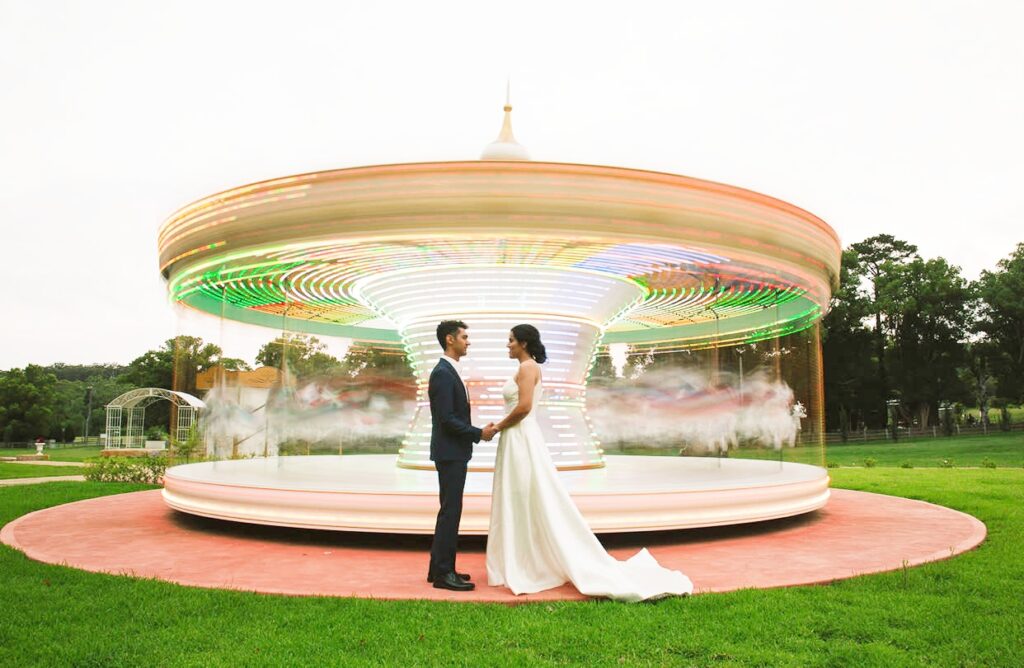 married couple in front of a quirk theme park ride