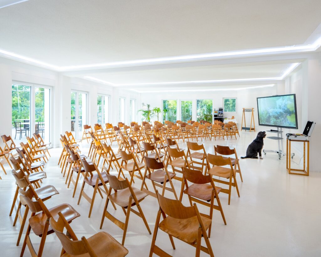 Large conference room with wooden chairs and a screen