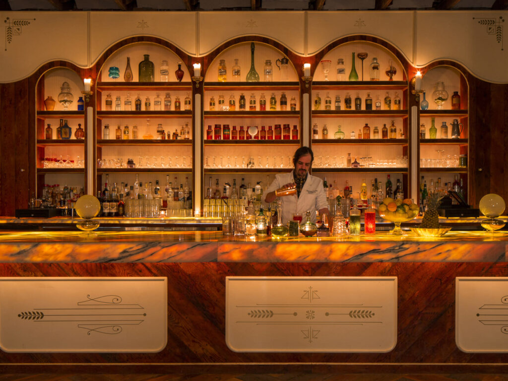 Bartender in a minimum spend venue for hire in London prepares cocktails for guests