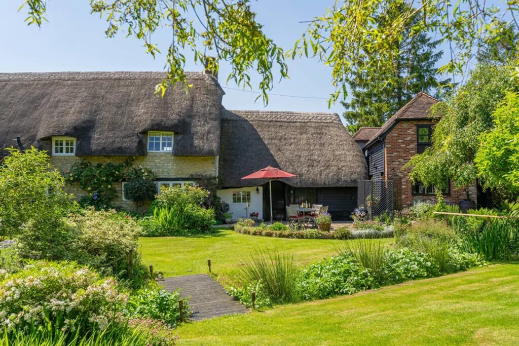 16th-century thatched stone cottage in the UK with an extensive garden 
