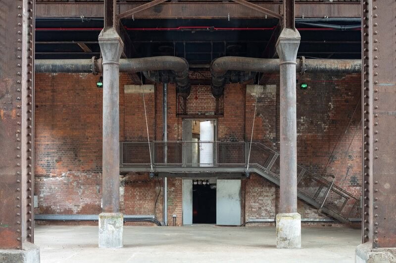 Cast iron columns, brick walls and pipework inside Wapping Hydraulic Power Station.