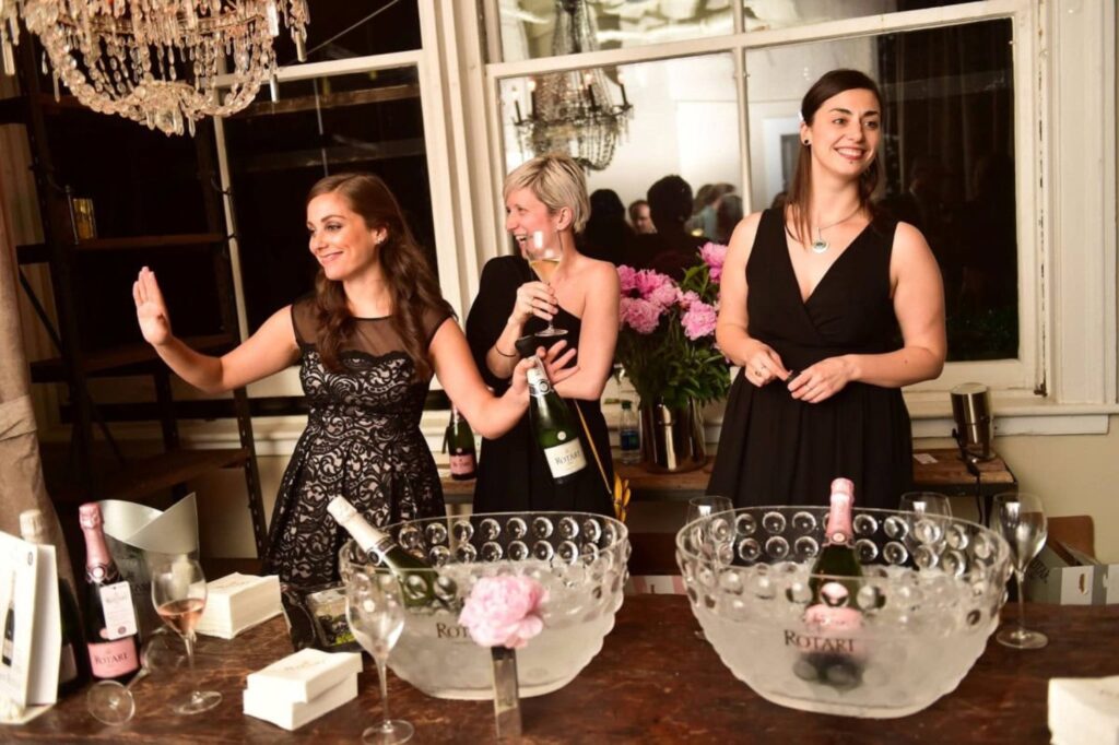 three female friends elegantly dressed at a party