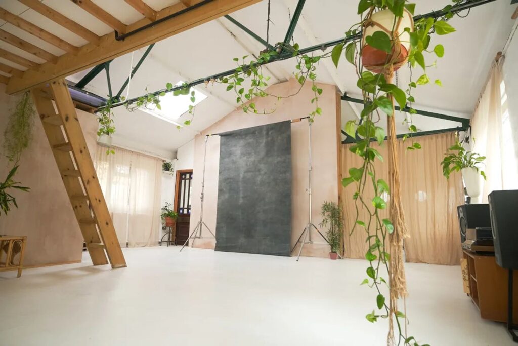 Warehouse venue in London with a phptoshoot setup, hanging plants and a wooden platform