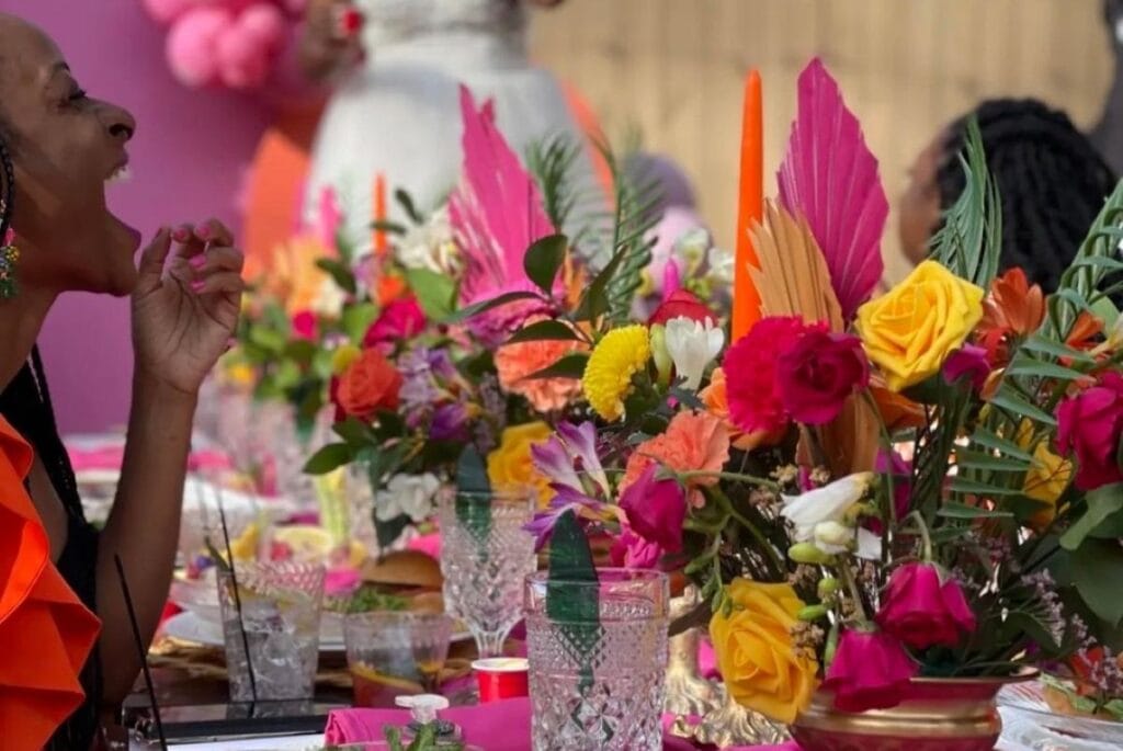 woman laughing at a brightly decorated dining table
