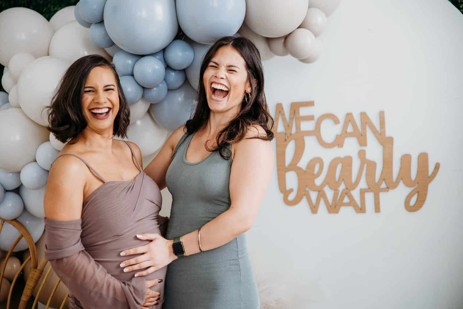 women holding a baby bump together