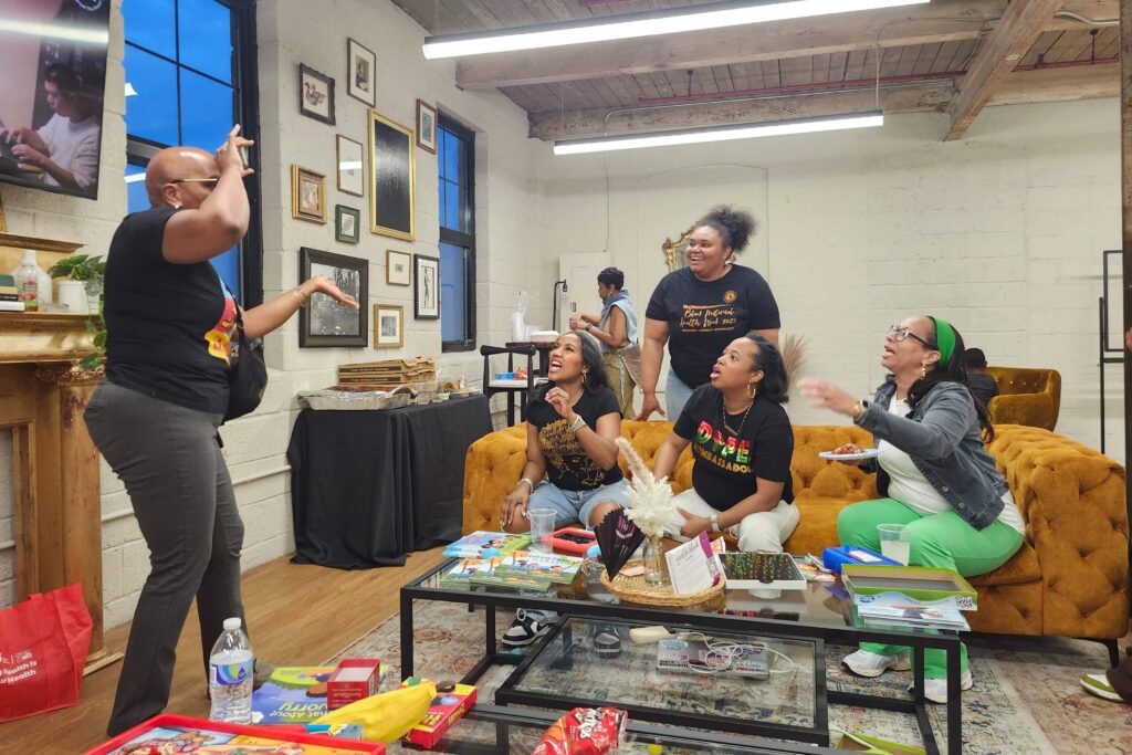 Women playing pantomime in a lounge